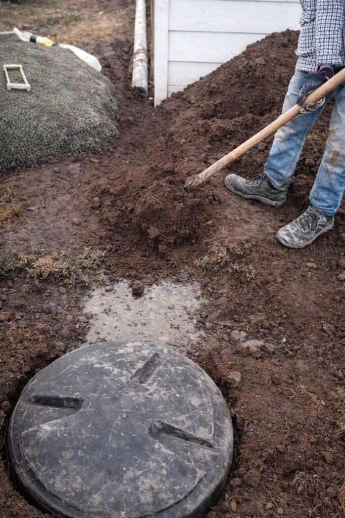 Trabajador excavando junto a tanque séptico